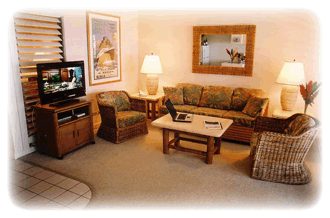 Living room with plantation shutters and lanai access at Kiahuna 22